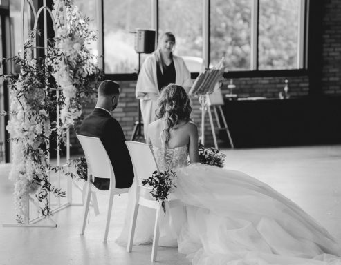 Hochzeitszeremonie mit Braut und Bräutigam, im Hintergrund ein Zeremonienleiter.